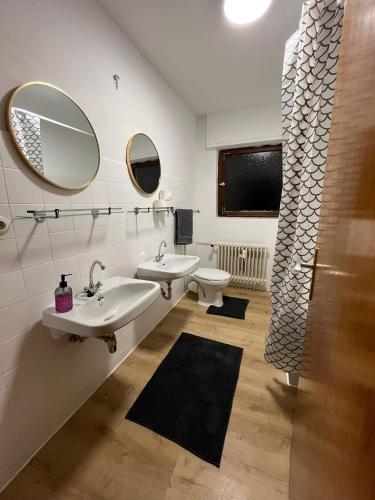 a bathroom with two sinks and two mirrors at Rodgau Work & Sleep in Rodgau