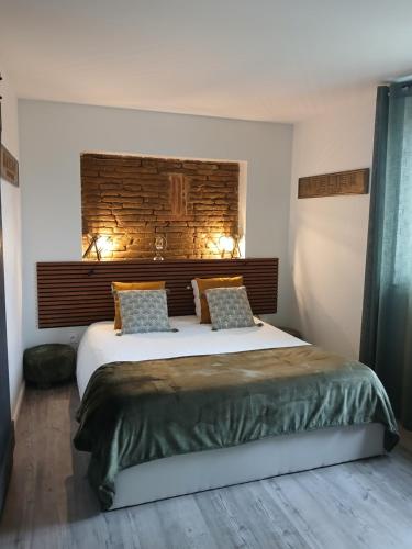 a bedroom with a large bed with two pillows at La ferme de Pham in Belberaud