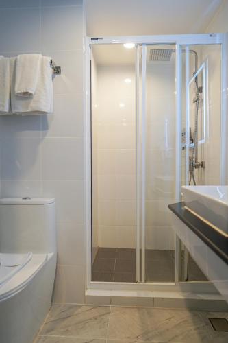 a bathroom with a shower and a toilet and a sink at 12 The Residence Hotel at Don Mueang Airport in Bangkok