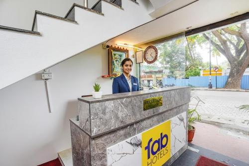 um homem parado atrás de um balcão num edifício em Via RLV Green Palace - Nr Kengeri Satellite Town em Bangalore