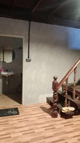 een houten trap in een kamer met een wastafel bij Baan Chok Dee Homestay in Chiang Khan