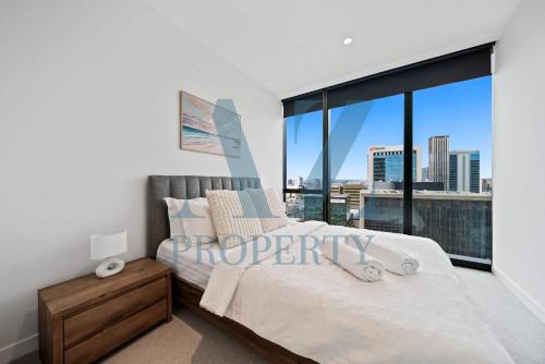 a bedroom with a bed and a large window at Luxury Perth CBD Apartment with Pool & Gym - Sleeps 3 in Perth