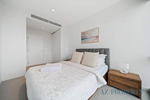 珀斯Luxury Perth CBD Apartment with Pool & Gym - Sleeps 3的白色卧室设有一张大床和镜子