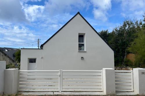 una casa bianca con una recinzione bianca di Maison Tamaris avec jardin et clos a Quiberon