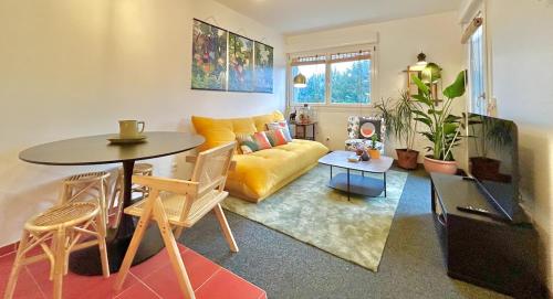 un soggiorno con un divano giallo e un tavolo di Sweet Jungle - Stylish, Cozy and Romantic - Colmar a Bollwiller