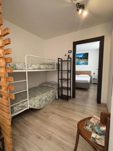 a room with two bunk beds and a table at Appartamenti Sasso Rosso in Commezzadura