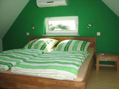 een groene slaapkamer met een bed met groene muren bij Ferienhaus Enger in Beulwitz
