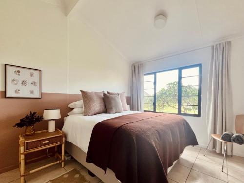 a bedroom with a large bed and a window at Sandpiper Cottage in Fish Hoek