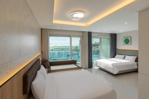 a hotel room with two beds and a window at New CZ Nampo Hotel in Busan