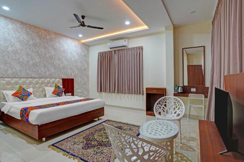ein Schlafzimmer mit Bett und ein Wohnzimmer in der Unterkunft FabHotel Lakewood Gardenia in Bangalore