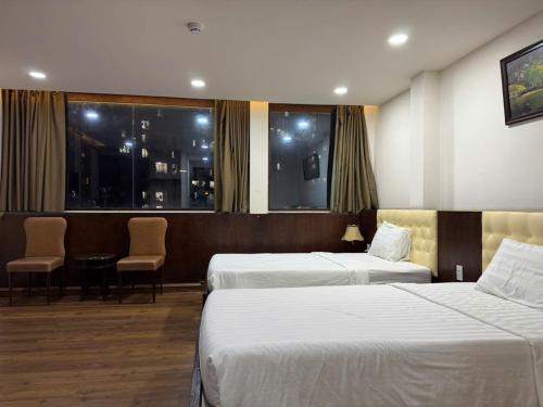 Khách sạn Anh Đức 1 في Ga Phú Văn: غرفة فندقية تحتوي على سريرين وطاولة وكراسي