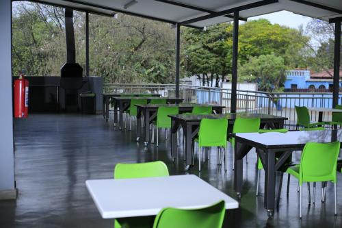 ラステンバーグにあるGreen Side accommodationのテーブルと緑の椅子が置かれた空のカフェテリア