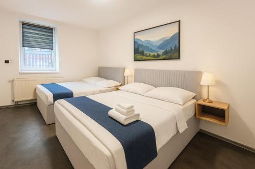 two beds in a small room with two lamps at Ideal for Big Groups, Modern 14 Guest Apartment Near Prague in Rakovník