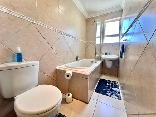 a bathroom with a toilet and a tub and a sink at Sea la vie at Jbay in Jeffreys Bay