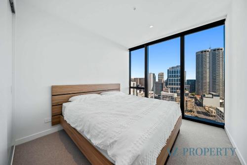 a bedroom with a bed and a large window at Bright & Spacious 2BR in Prime CBD Location in Perth