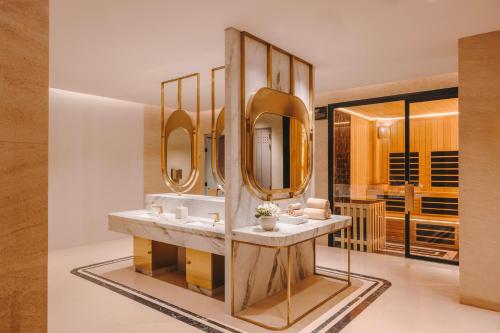 Un baño con un lavabo con espejos en la pared. en Roswyn, a Morgans Originals hotel, en Bombay