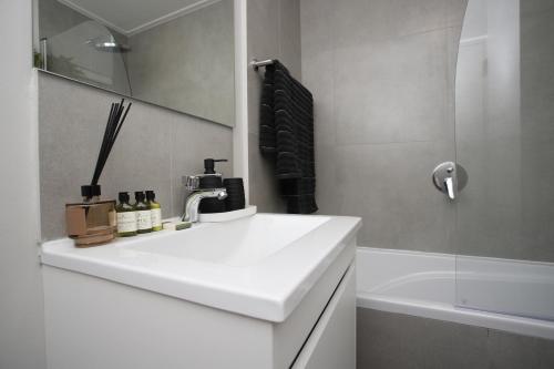 克尼斯纳302 Seahorse - Premium 2 Bedroom Unit with Pool & Parking的带白色水槽和浴缸的浴室