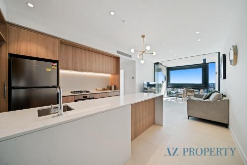 a kitchen with a large white counter with a refrigerator at 1BR Apartment in the Heart of the CBD in Perth