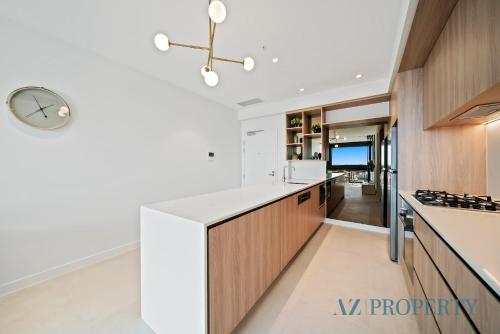 a kitchen with white counters and a clock on the wall at 1BR Apartment in the Heart of the CBD in Perth