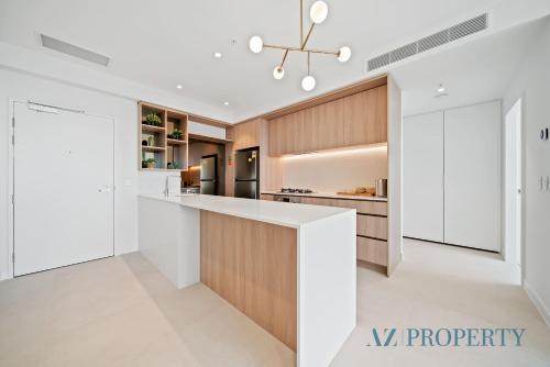 a kitchen with white and wood cabinets and a counter at 1BR Apartment in the Heart of the CBD in Perth