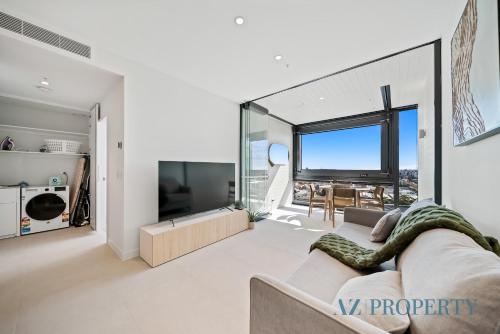 a living room with a couch and a large window at 1BR Apartment in the Heart of the CBD in Perth