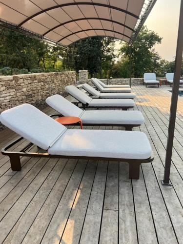 a row of lounge chairs on a wooden deck at La Villa des Cedres in Bonnieux