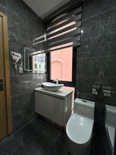 a bathroom with a white toilet and a sink at The Hanok Hotel Do Son in Hai Phong