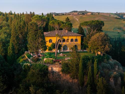 an estate in the hills with a yellow house at Villa MonteLandi in Montalcino