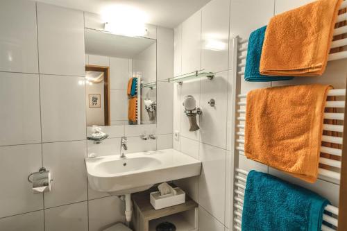 Haus Lucas Tschofen في Aussergosten: حمام مع حوض ومرآة ومناشف