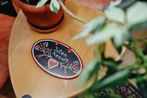 a wooden table with a plate on a table with a plant at Szárhegyi Vendégház in Lăzarea