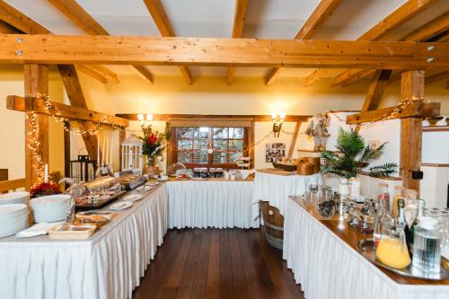Una gran sala con una línea de buffet con mesas blancas. en Landhotel im Hexenwinkel, en Wiernsheim