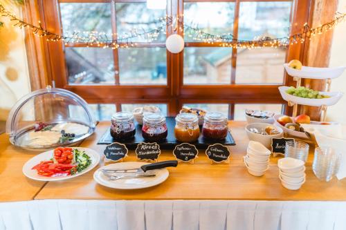 una mesa cubierta con platos de comida y tarros de mermelada en Landhotel im Hexenwinkel, en Wiernsheim