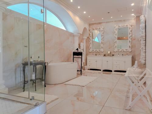 y baño con ducha, lavabo y espejo. en Grand Lux Boutique Manor, en Hermanus