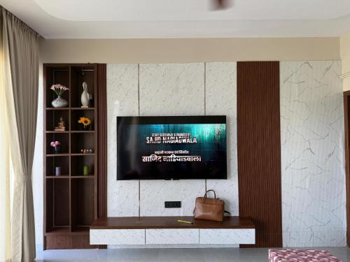Una sala de estar con un televisor en la pared. en Nuwara Eliya Karjat - 5BHK Villa, en Karjat