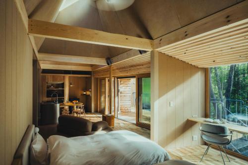 a bedroom of a house with a bed and a kitchen at SANU 2nd Home 八ヶ岳 3rd in Hokuto