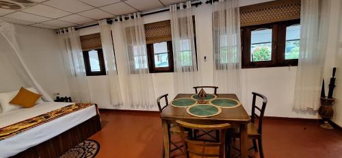 a bedroom with a bed and a table and chairs at Badulla Bliss in Badulla