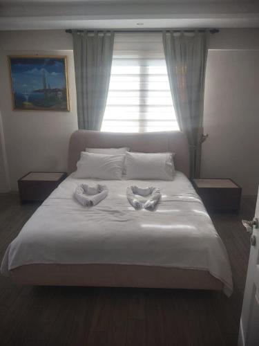 a bed with two towels on it with a window at Living House in Salihli