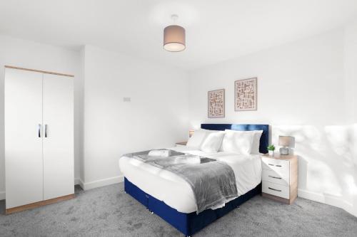 a white bedroom with a blue bed and a white closet at Perfect Booking 5 min Drive To Blyth Beach in Blythe