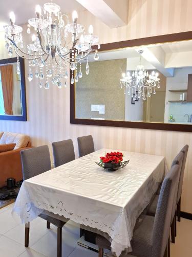 a dining room with a white table and chandelier at Partial Seaview with Wifi, Batu Ferringhi in Batu Ferringhi