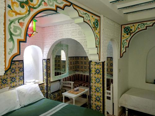 a bedroom with a bed and a table in a room at Dar Baaziz 2 in Sousse