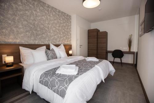 a bedroom with a large bed with two towels on it at Hochnegger Apartments in Eibiswald