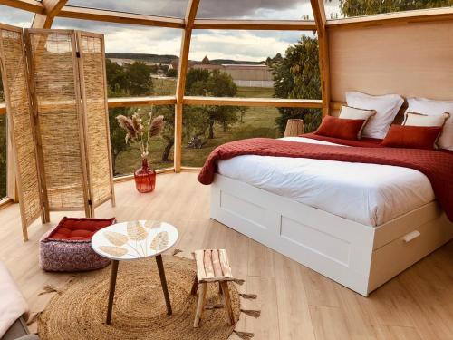 a bedroom with a large bed and a large window at Nuit’s Féerique en Champagne in Meurville
