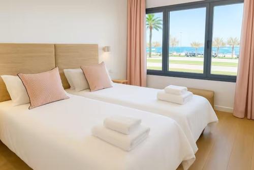 a bedroom with two beds with white sheets and a window at Playa Sardinero - Little Homes 1-2-3-5 in Santander