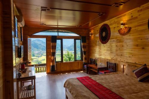a bedroom with a bed and a large window at Muong Hoa River View Hotel in Sa Pa