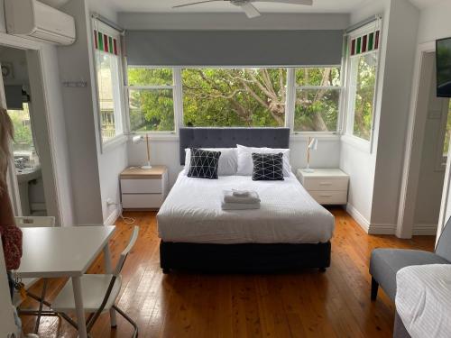 a bedroom with a bed and two windows at Royal Far West Lodge in Sydney