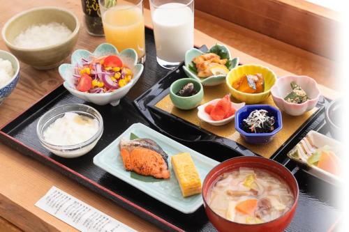 a table with plates of food and bowls of food at Nunohiki Onsen Komoro in Komoro