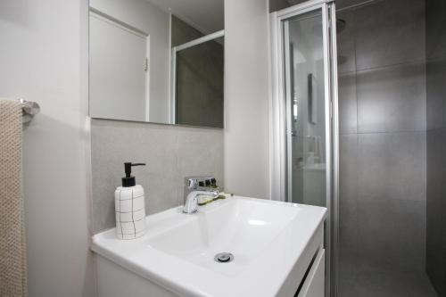 un bagno bianco con lavandino e doccia di 307 Seahorse - 1 Bedroom Premium Unit with Parking a Knysna