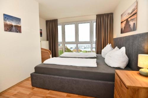 a bedroom with two beds and a large window at Frisch renoviertes FH Südblick am Meer in Breege, Meerblick von allen drei Etagen, Terrasse, Balkon, Sauna und Parkplatz in Breege