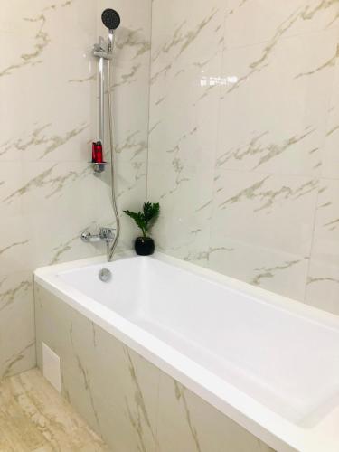 a bathtub in a bathroom with a plant in it at Sunset view Armoniei Apartament in Timişoara