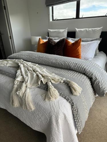 a bedroom with a white bed with pillows and a window at Duo Duo in Auckland